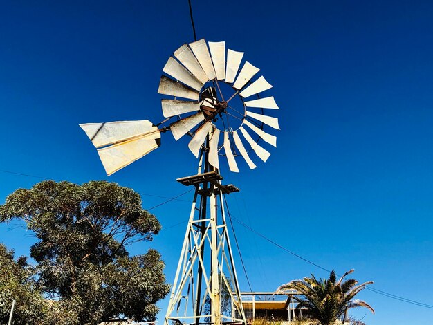 Low angle view of traditional windmill against clear blue sky