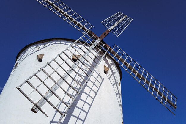 Low angle view of traditional windmill against clear blue sky