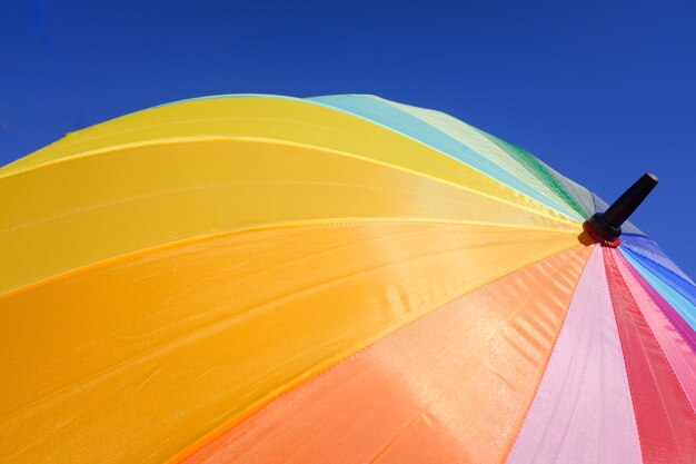 Low angle view of umbrella against clear blue sky