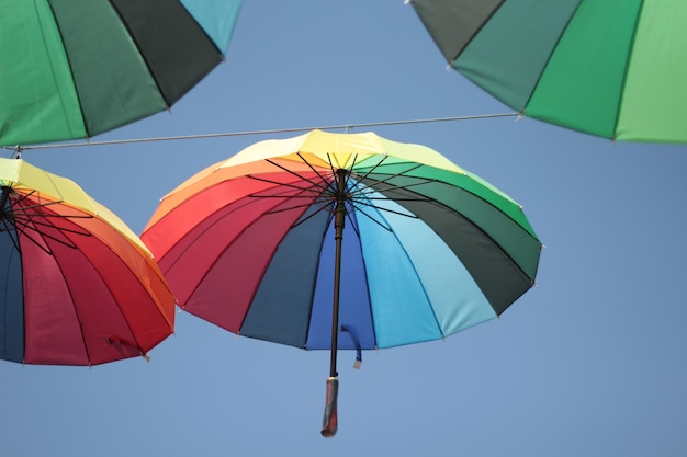 Low angle view of umbrellas against blue sky