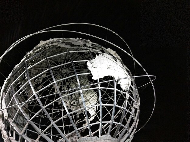 Low angle view of unisphere sculpture against clear sky at night