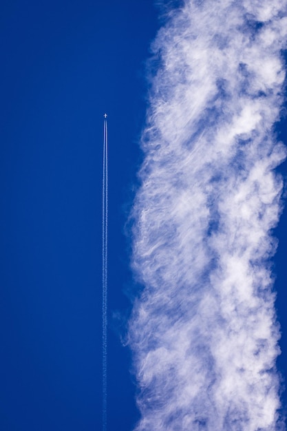 青い空を背景にした蒸気の足跡の低角度の眺め