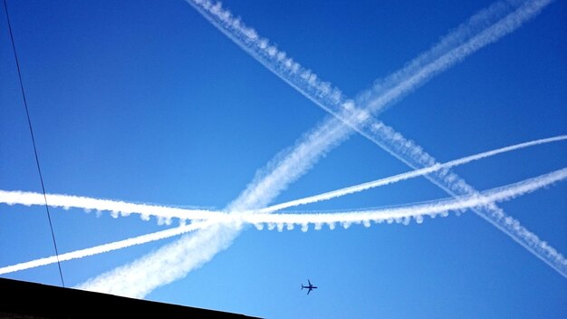 青い空を背景にした蒸気の足跡の低角度の眺め