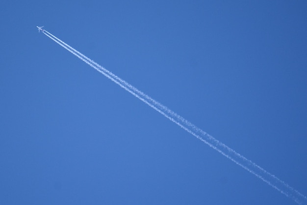 Foto vista a basso angolo della traccia di vapore contro un cielo blu limpido