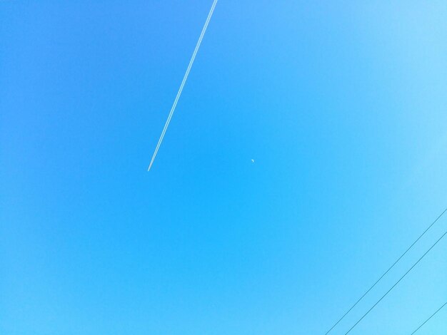 Low angle view of vapor trail against clear blue sky