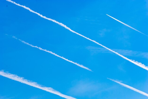 Foto vista a bassa angolazione delle tracce di vapore contro il cielo blu