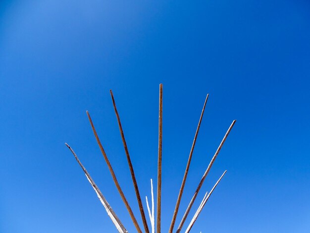 Low angle view of vapor trails against clear blue sky