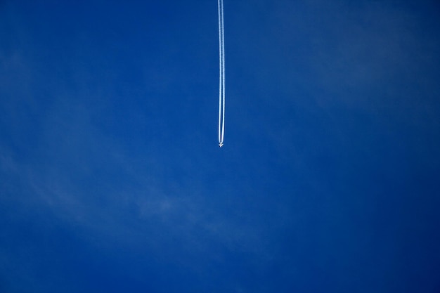 Low angle view of vapor trails in blue sky