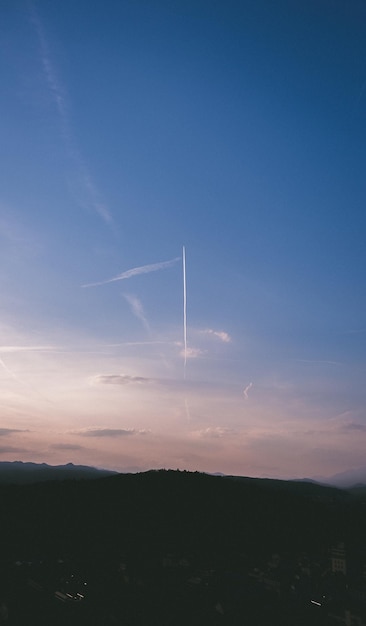 Photo low angle view of vapor trails in sky during sunset