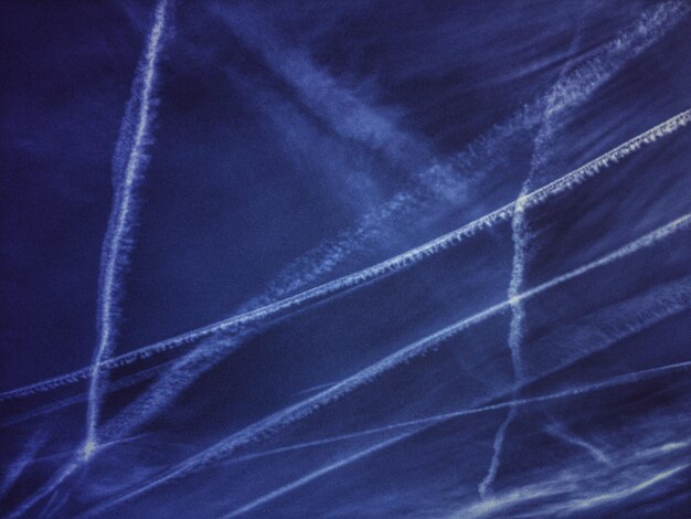 Photo low angle view of vapor trails in sky at dusk