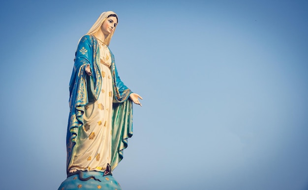 푸른 하늘 을 배경 으로 한 동상 인 동정녀 마리아 의 낮은 각도 시각