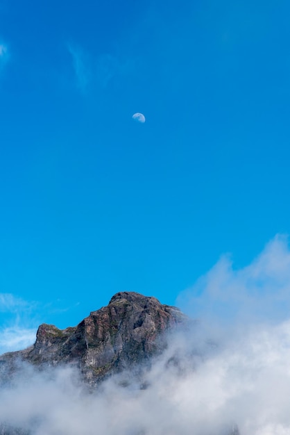 Low angle view of volcanic mountain against blue sky