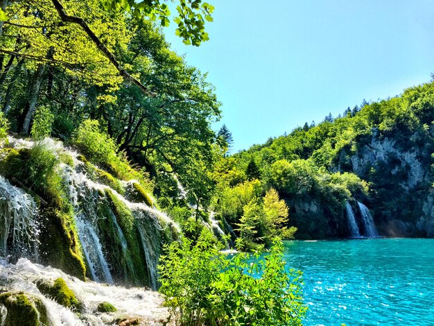 Foto vista a basso angolo della cascata dal lago contro il cielo