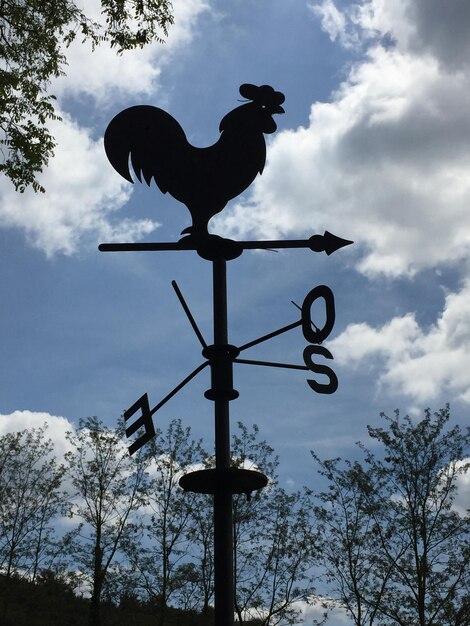 Photo low angle view of weather vane against cloudy sky