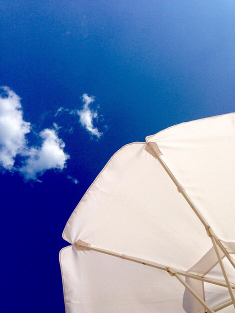 Low angle view of white umbrella against blue sky