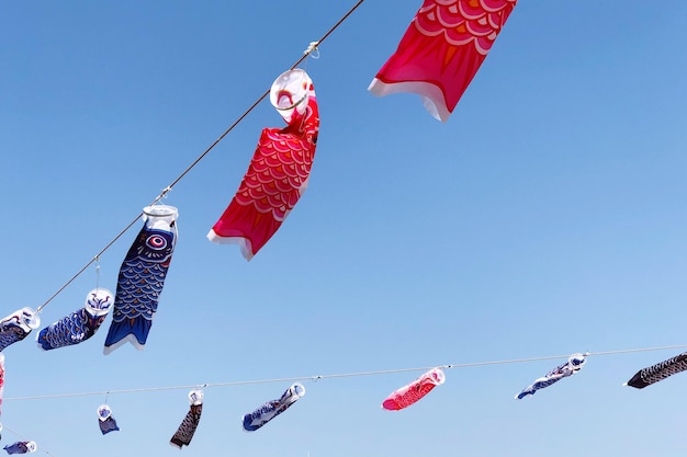 low angle view of wind socks hanging against clear blue sky