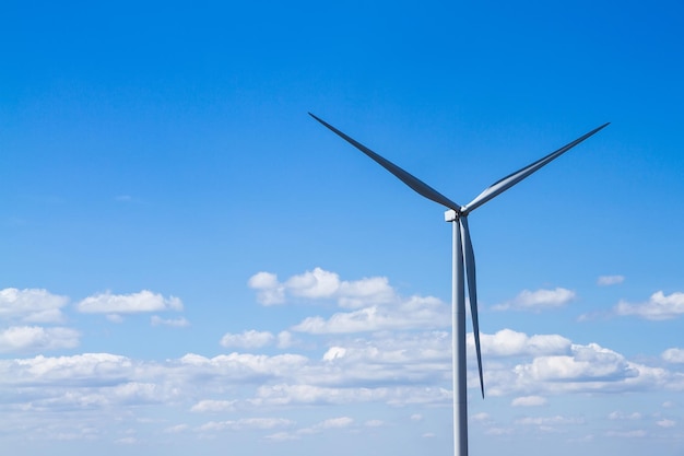 Low angle view of wind turbine against blue sky