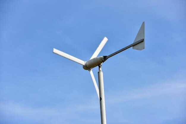 Low angle view of wind turbine against blue sky