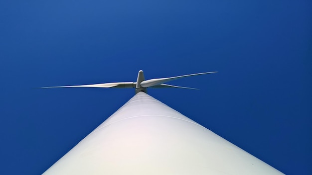 Foto vista a basso angolo della turbina eolica contro il cielo blu