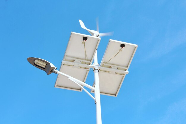 Low angle view of wind turbine against blue sky