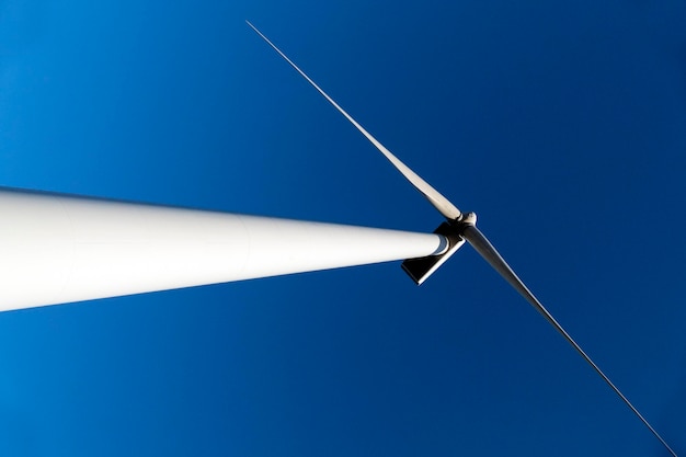 Low angle view of wind turbine against blue sky