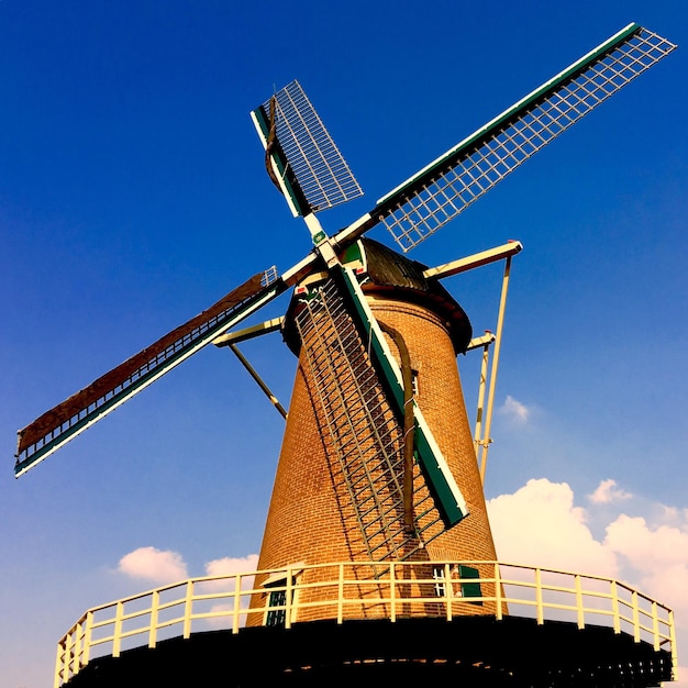 Low angle view of wind turbine against cloudy sky