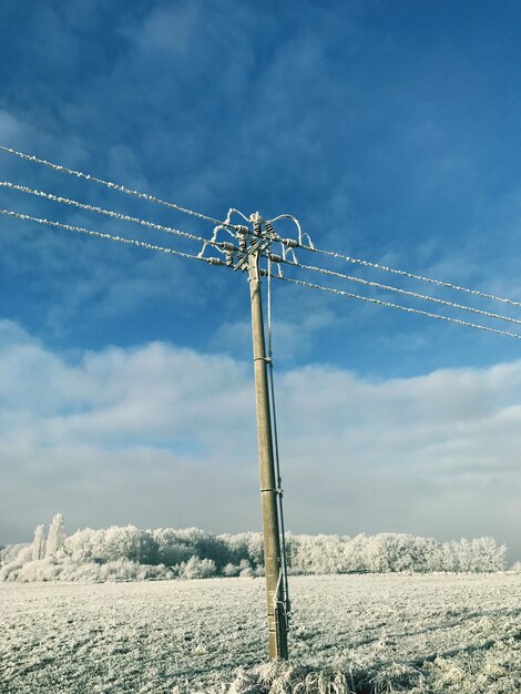 Low angle view of wind turbines against sky