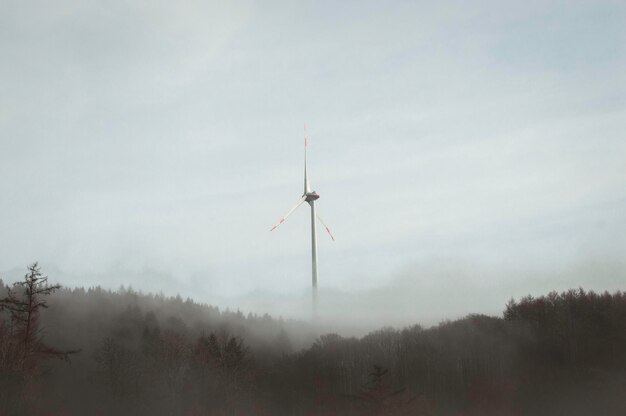 Photo low angle view of wind turbines against sky