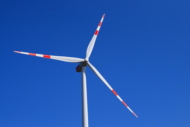 Low angle view of windmill against blue sky