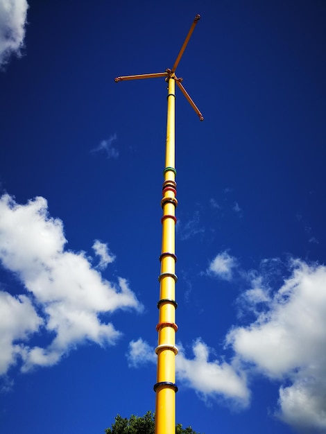 Low angle view of windmill against blue sky