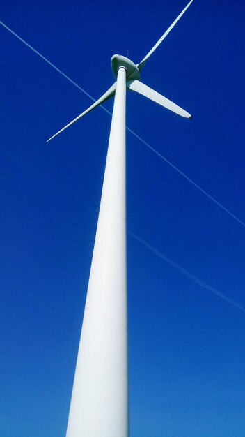 Photo low angle view of windmill against blue sky