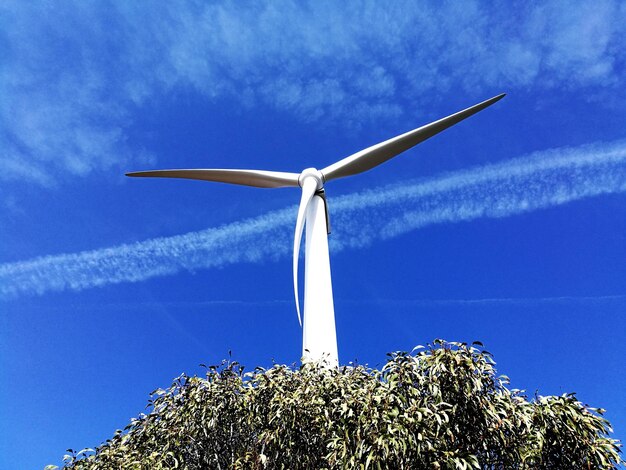 Low angle view of windmill against blue sky