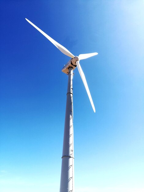 Photo low angle view of windmill against clear blue sky