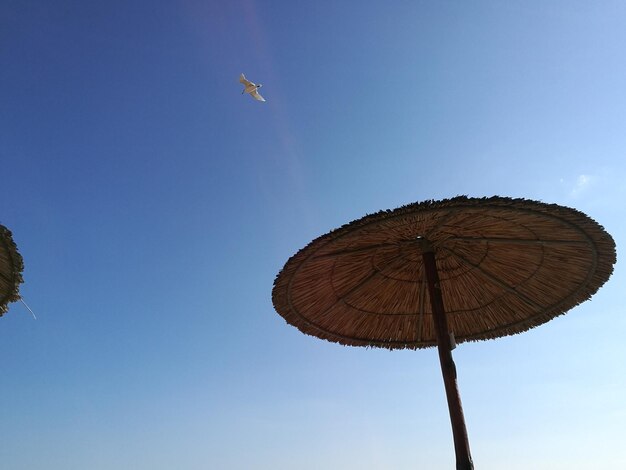 Low angle view of windmill against clear blue sky