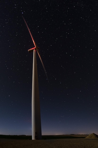 Foto vista a bassa angolazione del mulino a vento sul campo contro il cielo notturno