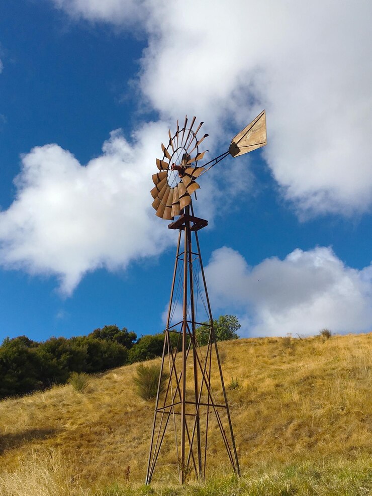 फोटो low angle view of windmill on field against sky