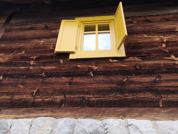 Low angle view of window on wooden wall of building