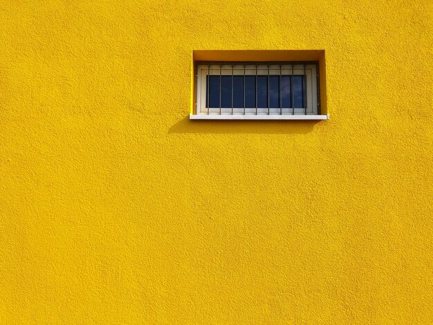 Low angle view of window in yellow building