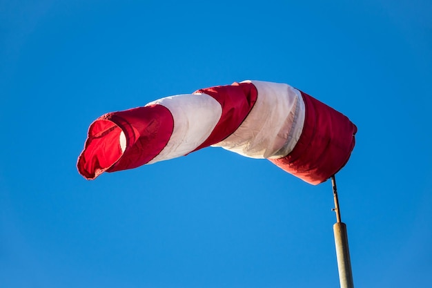 Foto vista a basso angolo di windsock contro un cielo blu chiaro durante una giornata di sole