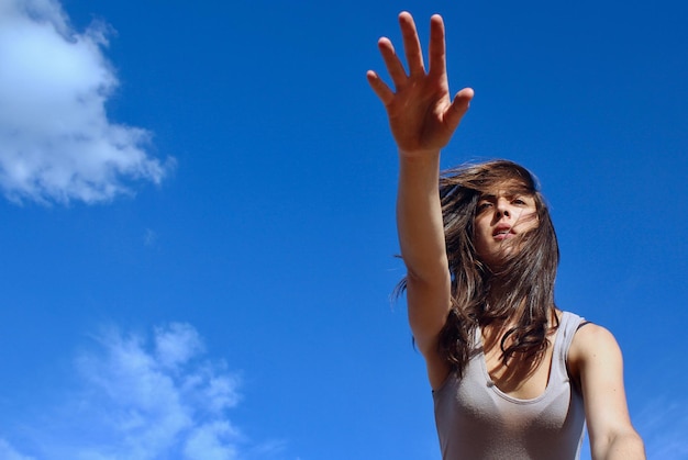 Low angle view of woman against blue sky