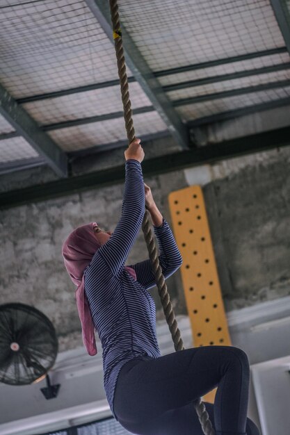 Foto vista a bassa angolazione di una donna che si arrampica sulla corda