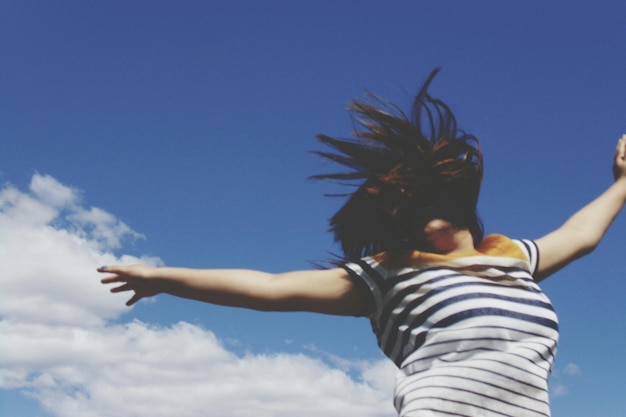Photo low angle view of woman jumping against sky