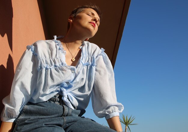 Photo low angle view of woman looking away against clear sky