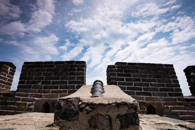 Photo low angle view of woman sitting against brick wall