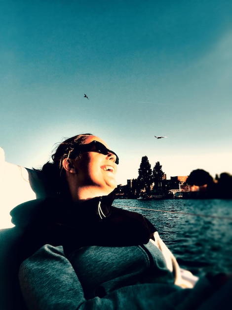 Low angle view of woman sitting in nautical vessel at river