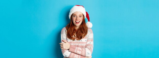 Low angle view of woman standing against blue background