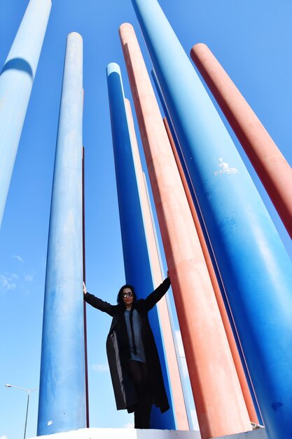 Low angle view of woman standing against blue sky