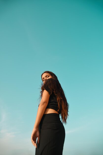 Photo low angle view of woman standing against clear blue sky