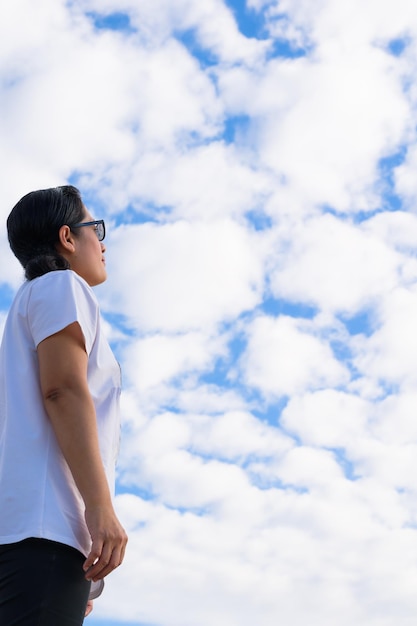 Photo low angle view of woman standing against cloudy sky