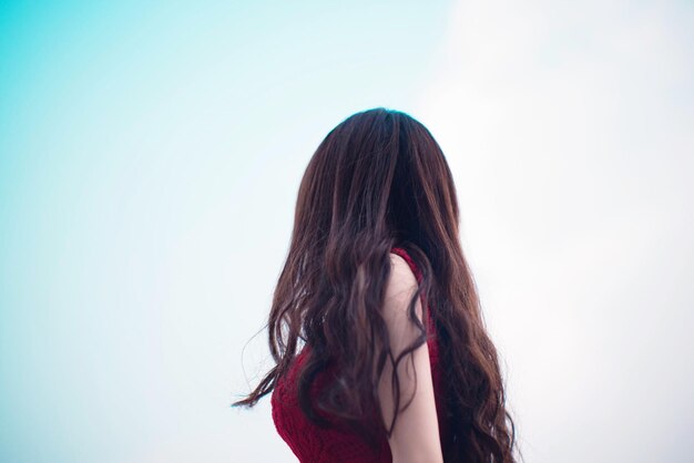 Low angle view of woman standing against sky